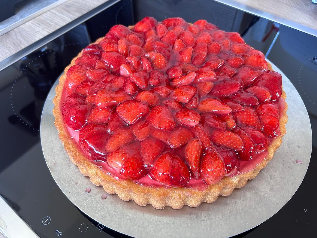 Erdbeerkuchen mit glänzender Gelee-Schicht auf hellem Mürbeteigboden
