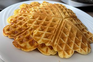 Mehrere herzförmige Waffeln mit Waffelmuster auf einem weißen Teller