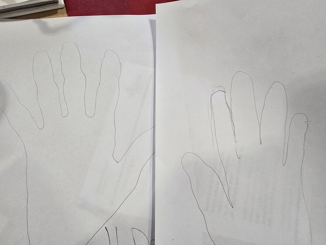 Zwei auf weißem Papier gezeichnete Umrisse von Händen nebeneinander