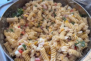 Große Schüssel mit Fusilli-Nudelsalat, gemischt mit kleinen Gemüsestücken und Kräutern