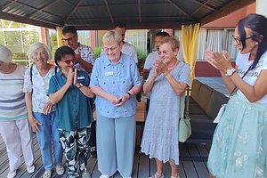 Feierliche Eröffnung mit einer Gruppe fröhlicher Menschen, die applaudieren und jubeln.