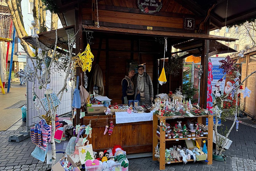 Holzhütte mit Verkaufsstand, dekoriert mit Weihnachtsartikeln und handgemachten Geschenken.