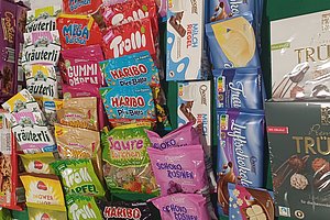 Bunte Ansammlung von Süßigkeiten und Snacks, darunter Haribo, Trolli und Trüffelboxen.